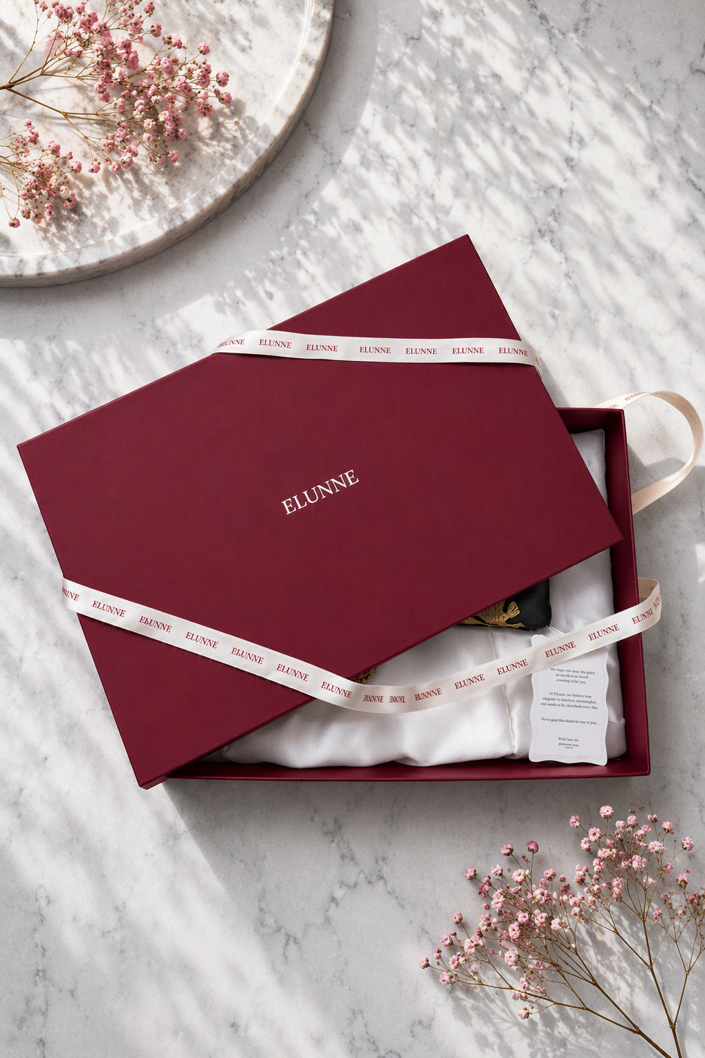 Elunne's signature packaging- open lid with ribbon, satin and note